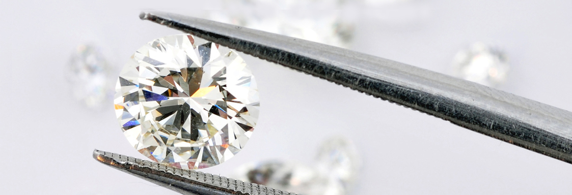 Ein Diamant wird mit Hilfe einer Pinzette gehalten. 